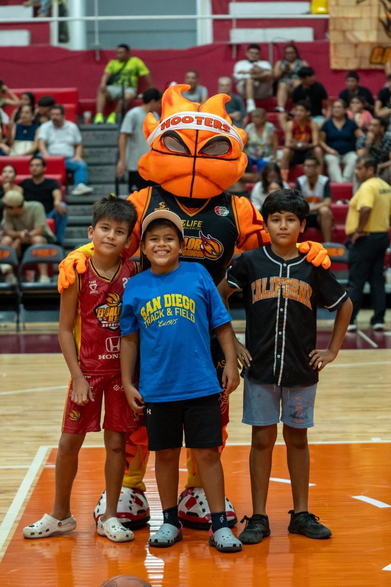 Niños de la academia con la mascota Flama